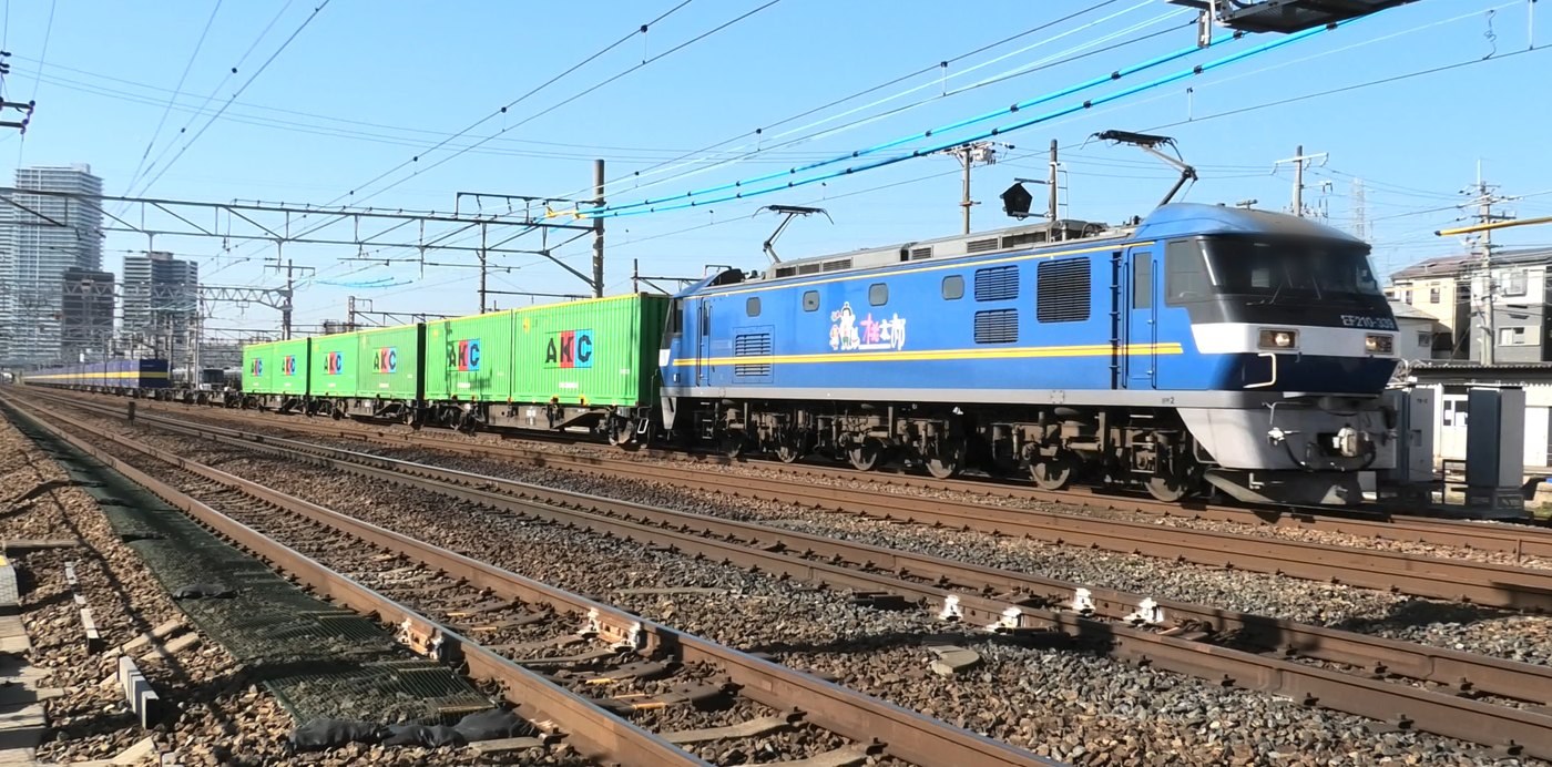 EF210形電気機関車「桃太郎」がコンテナ貨物を引いて安満遺跡公園ぞいを通過