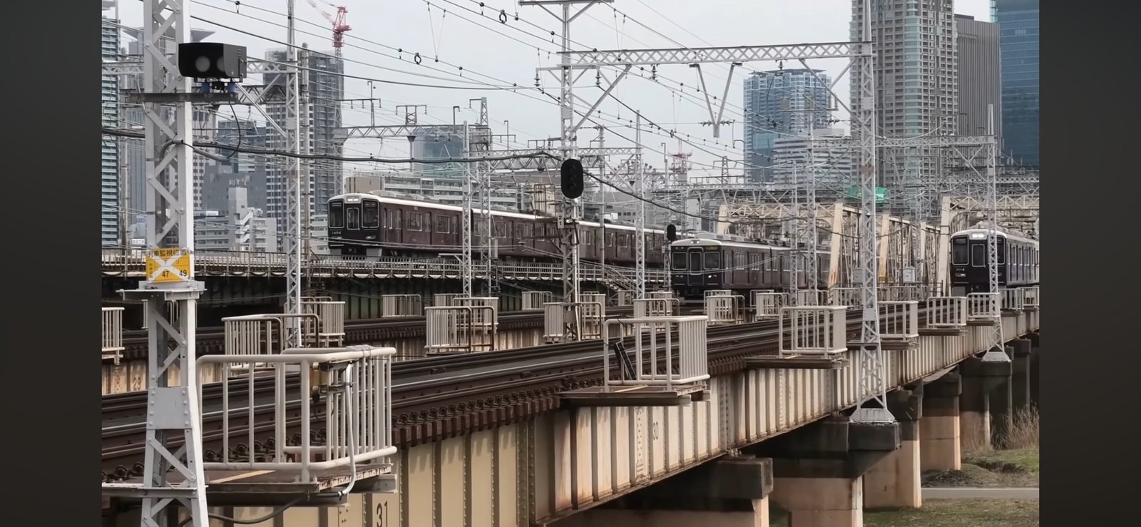 阪急の神戸線・宝塚線・京都線の電車が淀川の鉄橋を同時に渡る様子（十三大橋付近）