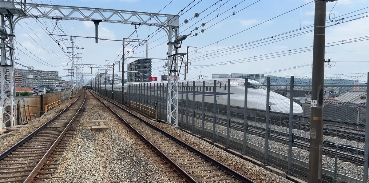 上牧駅のホームの京都側の端から見た景色。右をN700Sが通過し、左奥から阪急の電車が近づいてくる
