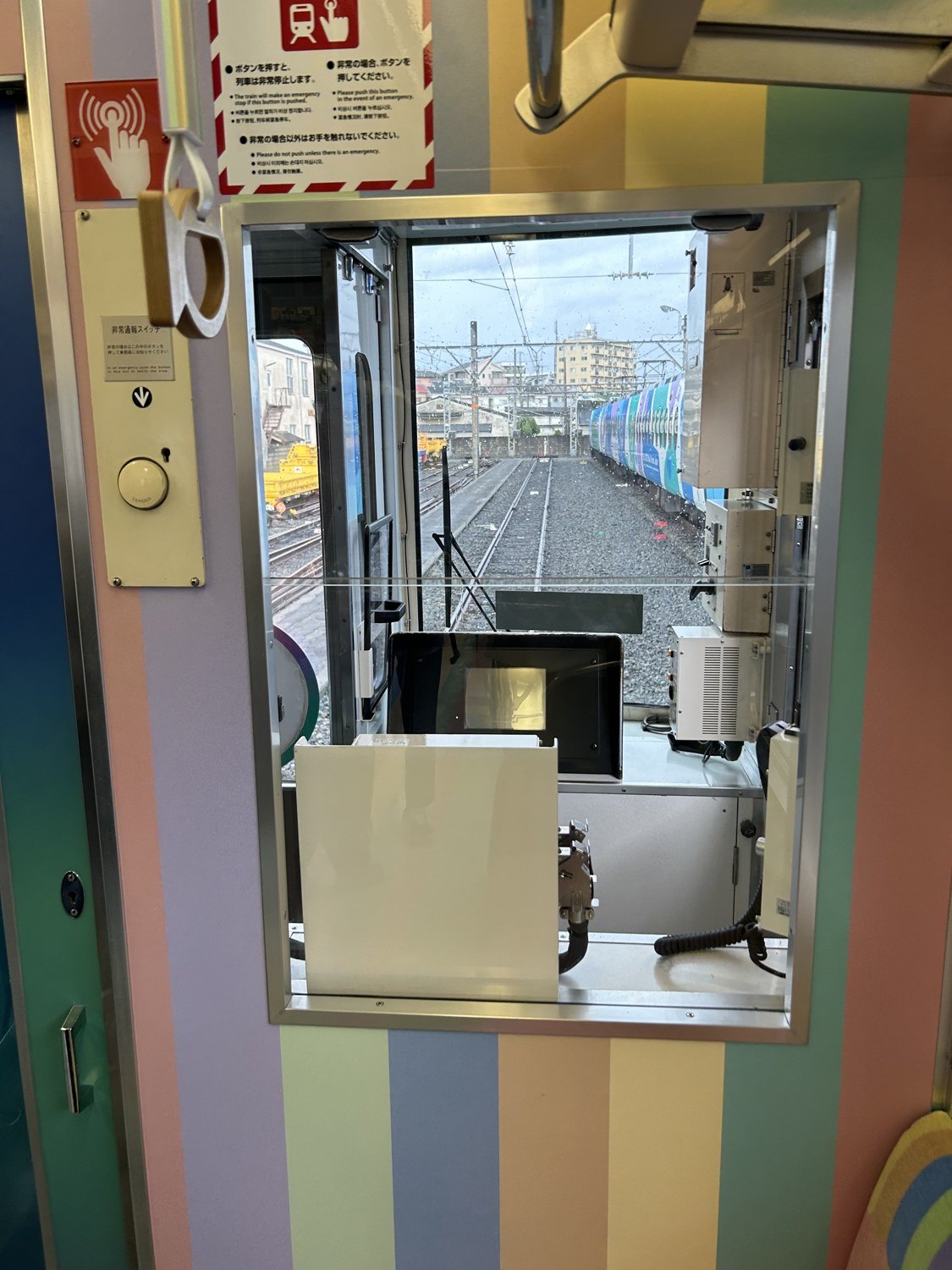 めでたいでんしゃ かなたの運転台うしろから見た前面展望。パステルカラーの車内と工場の線路
