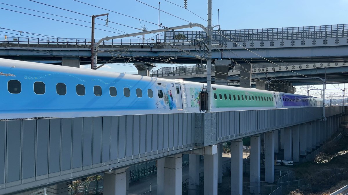 大山崎の歩道橋の目の前を通るディズニーのラッピング新幹線（ワンダフルドリーム新幹線）。アナと雪の女王の絵柄