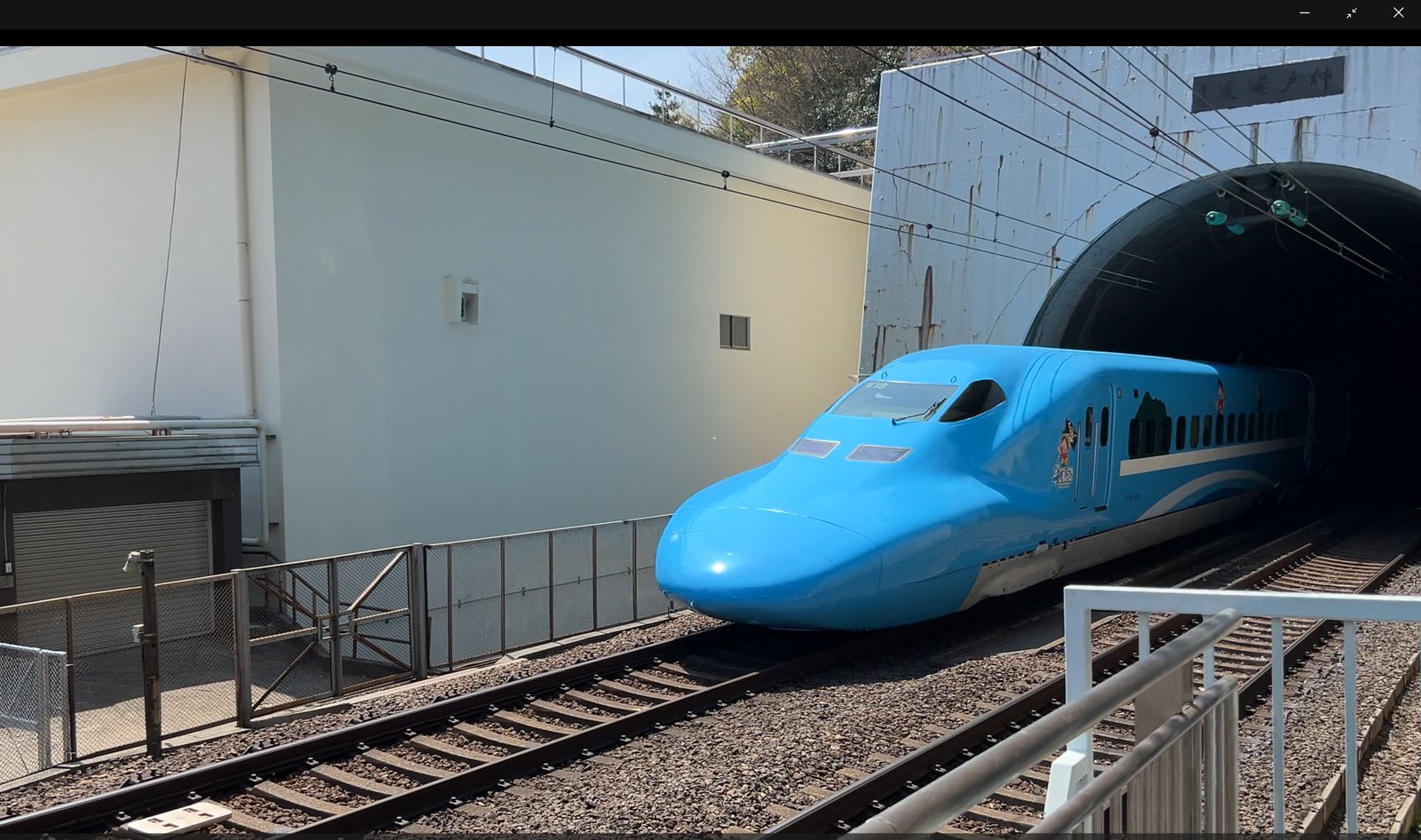 新神戸駅でトンネルから現れたキャラクターのラッピング新幹線