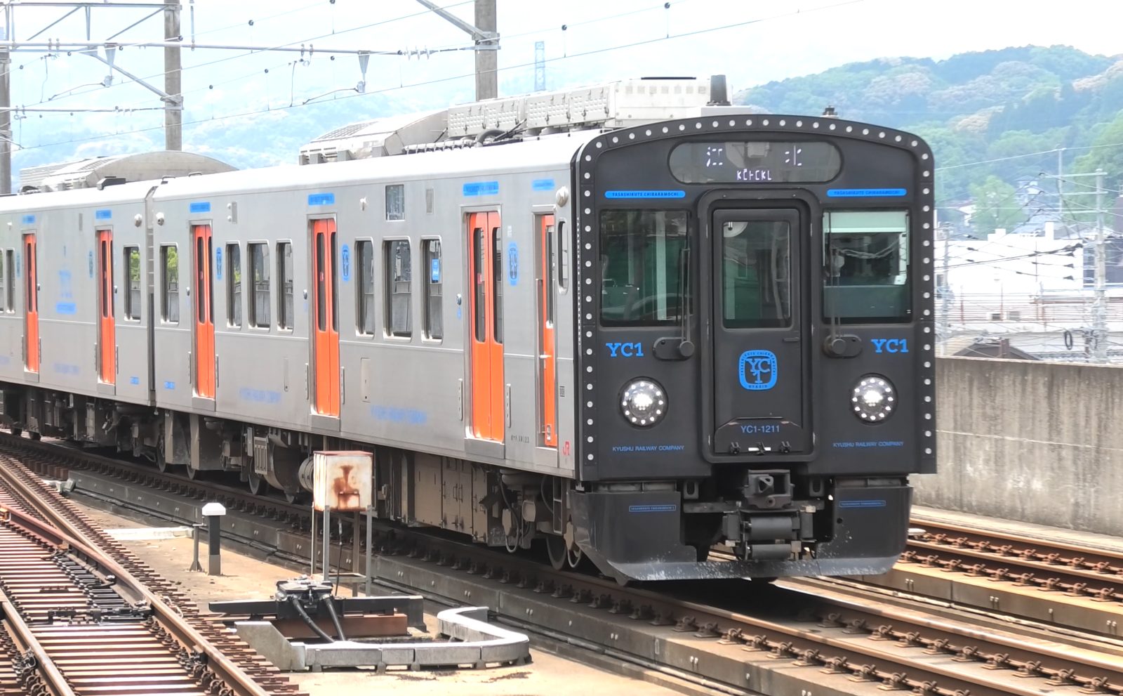 武雄温泉駅の在来線ホームに停まるハイブリッド車YC1系（黒い前面）