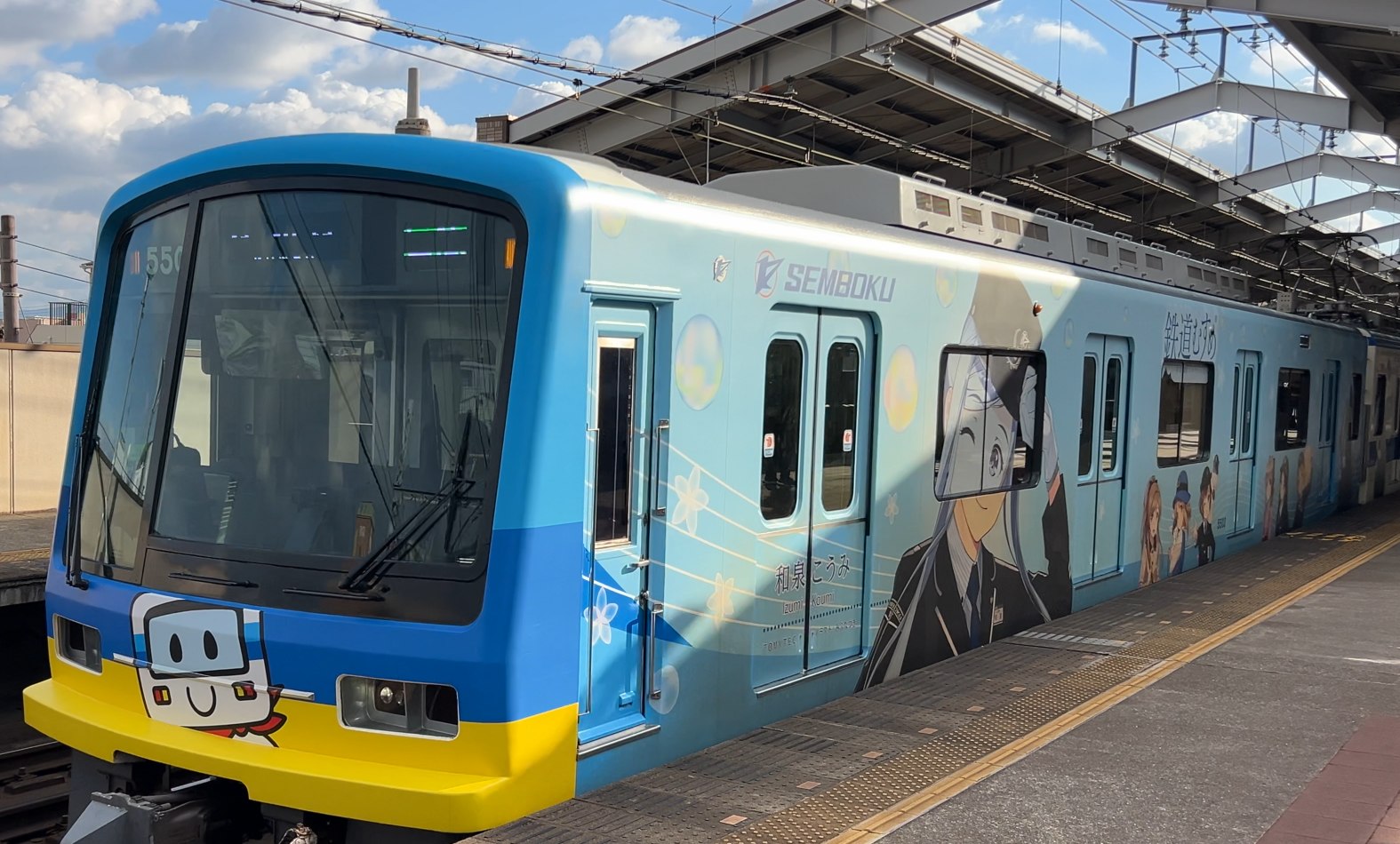 南海 天下茶屋駅にやってきた泉北線のラッピング車両（水色の車体にキャラクター）