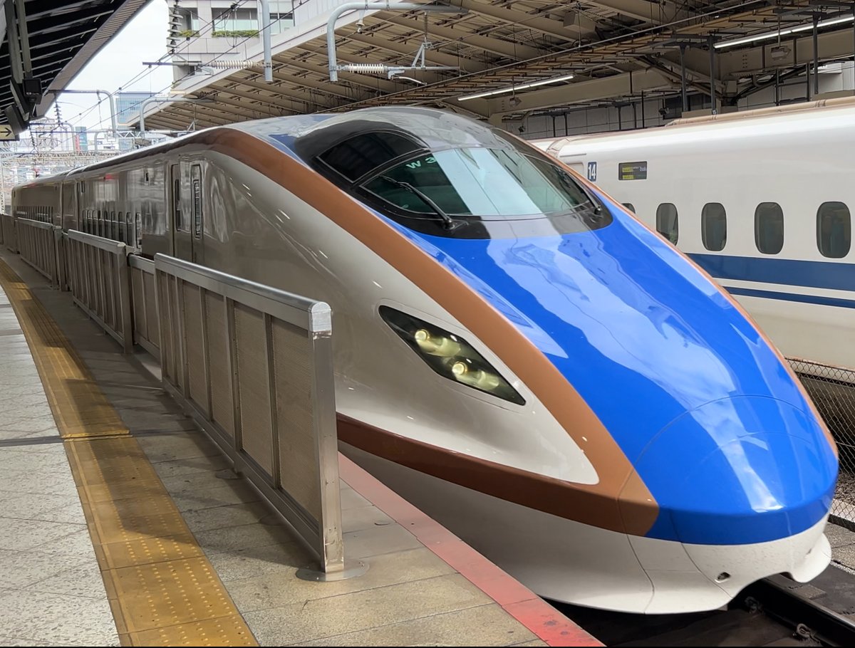 東京駅に停車中のW7系かがやきと、奥に東海道新幹線N700系