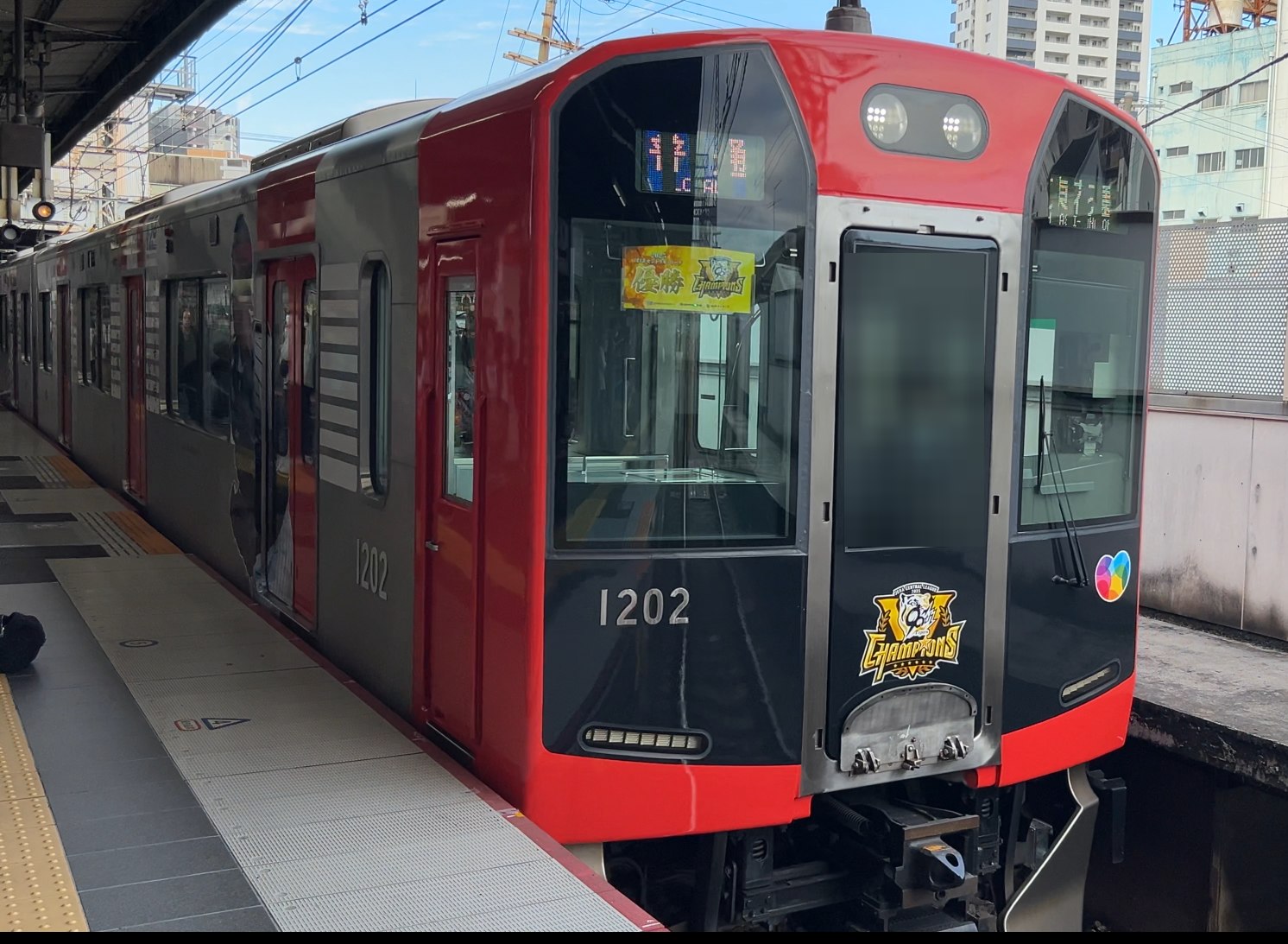 鶴橋駅に乗り入れた阪神電車の「阪神タイガース優勝」記念ラッピング車（赤い車体）
