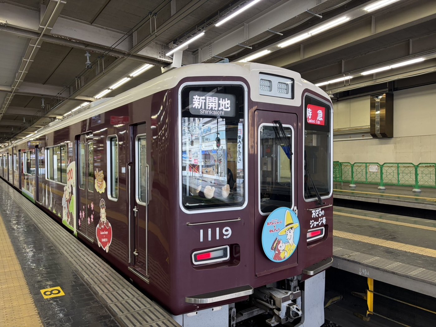 阪急おさるのジョージ号 神戸線1119編成。水色のヘッドマークと側面のラッピング