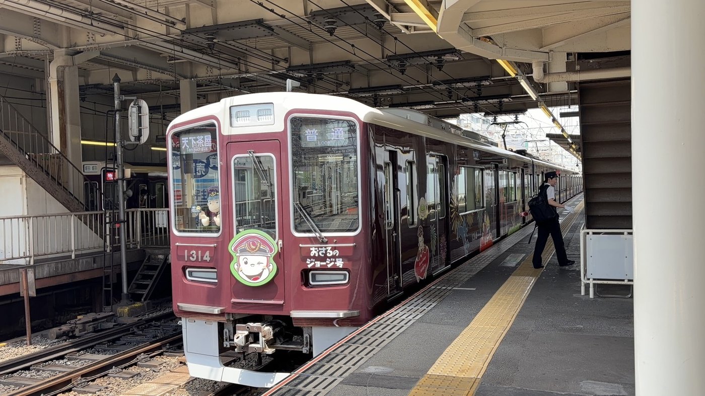 阪急おさるのジョージ号 京都線1314編成。緑のふちに駅員帽のジョージのヘッドマーク